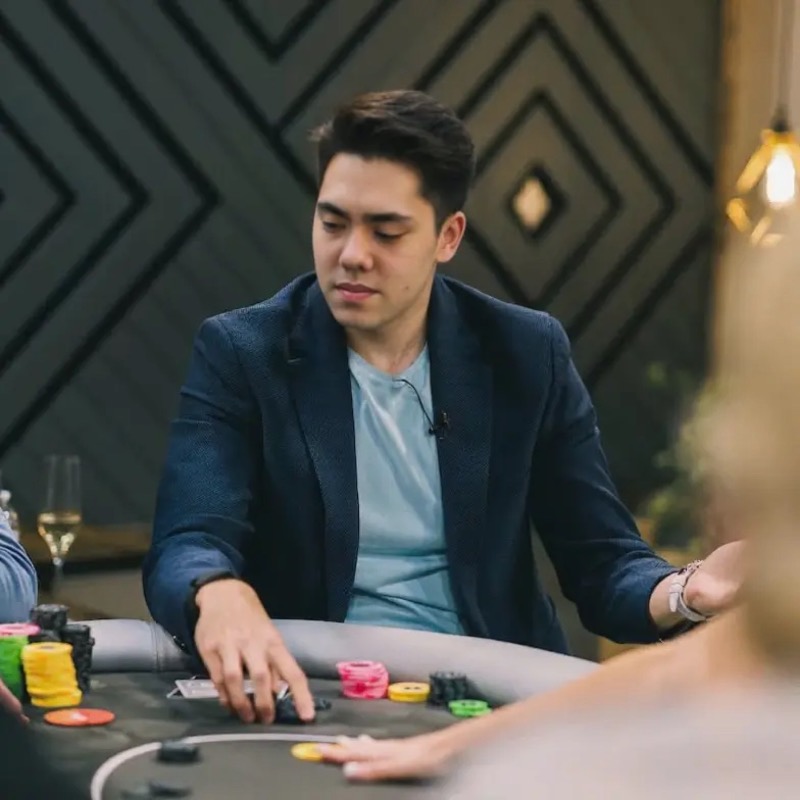 Matthew Stevens in a navy blazer at a card table, looking down at the chips