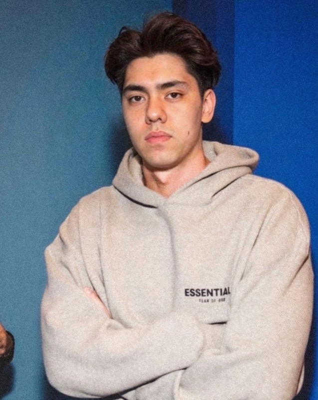 Matthew Stevens in a grey hoodie against a blue wall